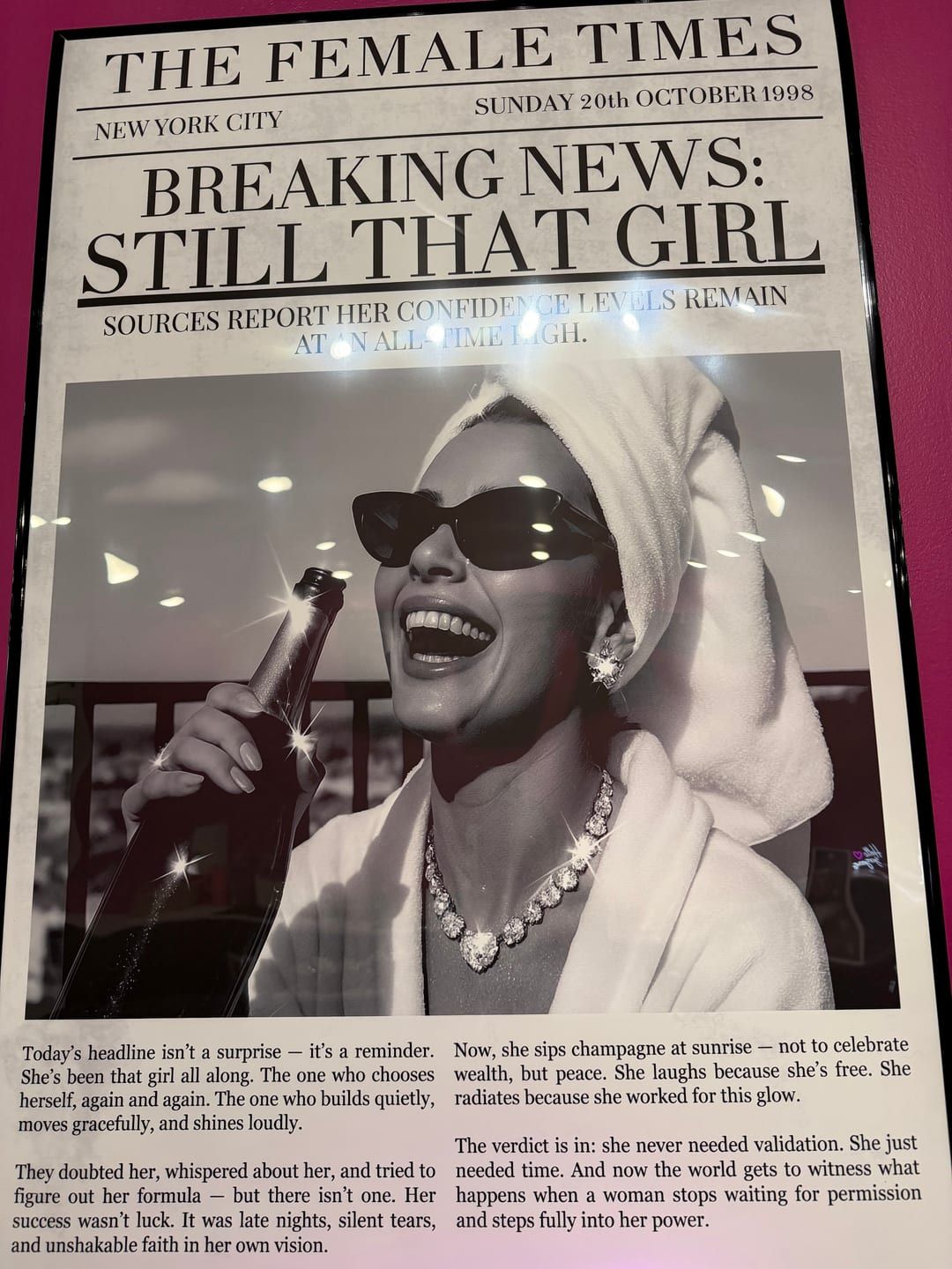 Framed 'Female Times' art on the shop's pink wall
